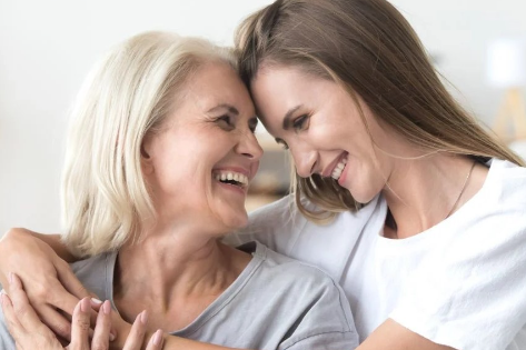 мама і доросла донька розмовляють з усмішкою