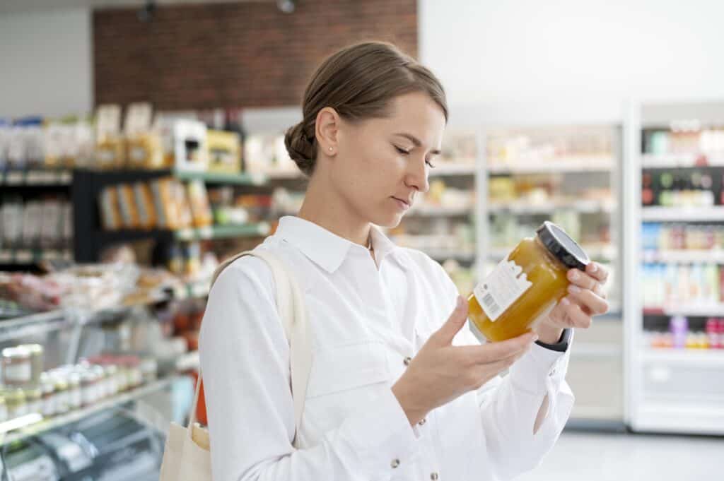 як не купити підроблені продукти — жінка перевіряє етикетку в магазині |©freepik.com| tviyden.com