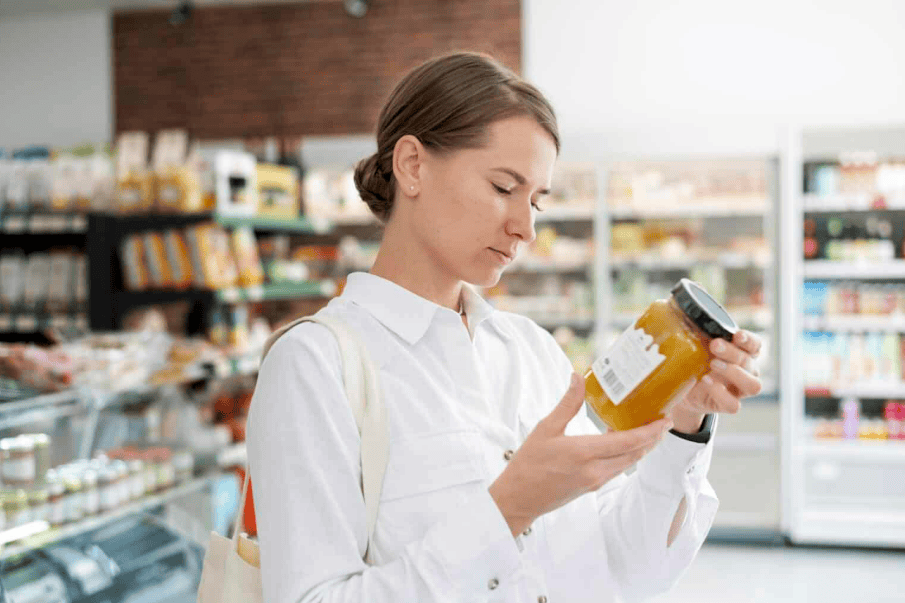 як не купити підроблені продукти — жінка перевіряє етикетку в магазині |©freepik.com| tviyden.com